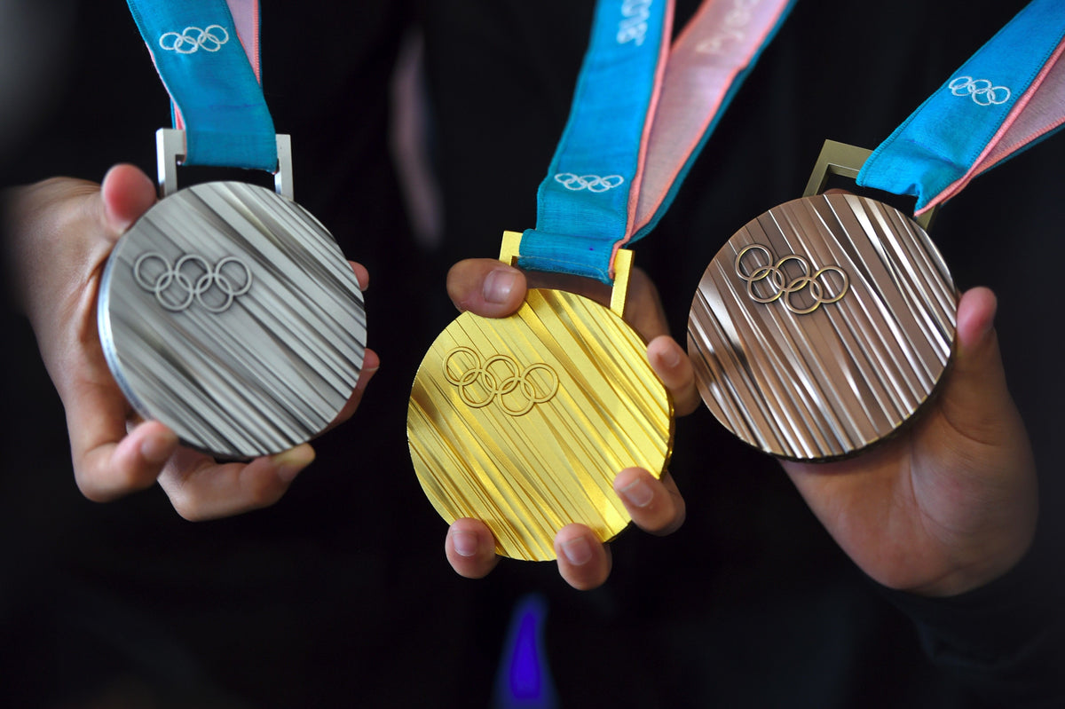 De geschiedenis van goud, zilver en brons bij prijsuitreikingen